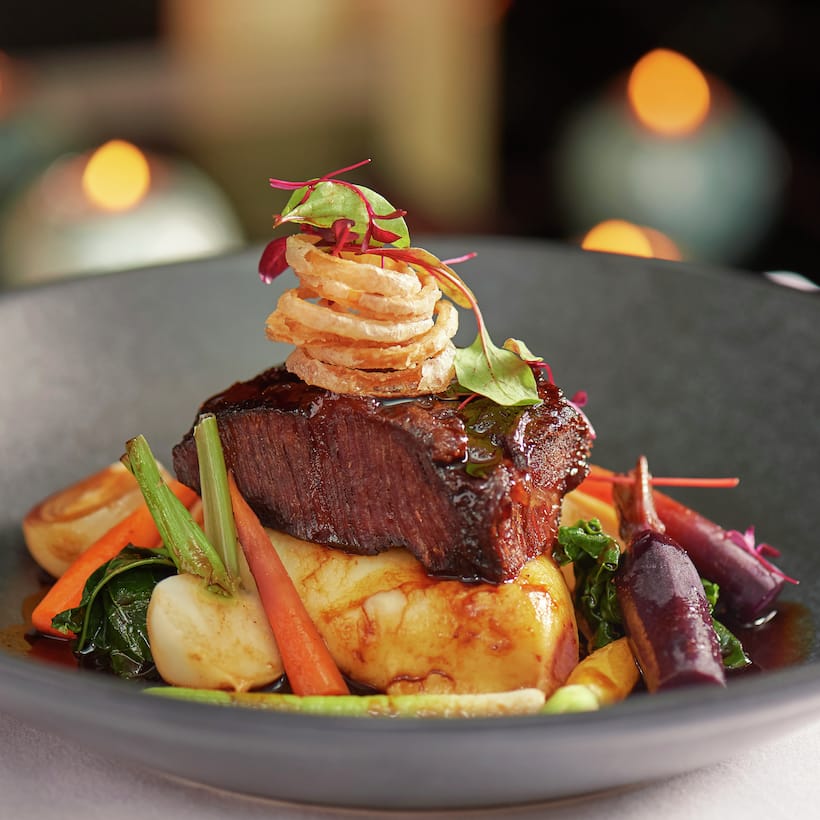Steak grillé sur un lit de légumes rôtis