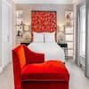 Room with double bed, red headboard and red sofa