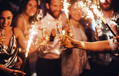 Crowd of people with sparklers and glasses of champagne