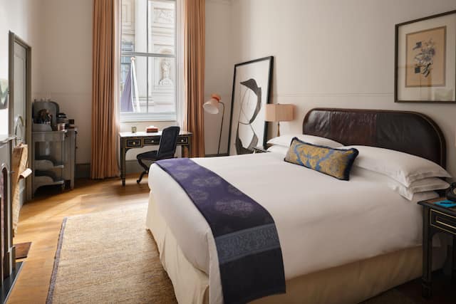 Bed in room with TV, work desk and chair