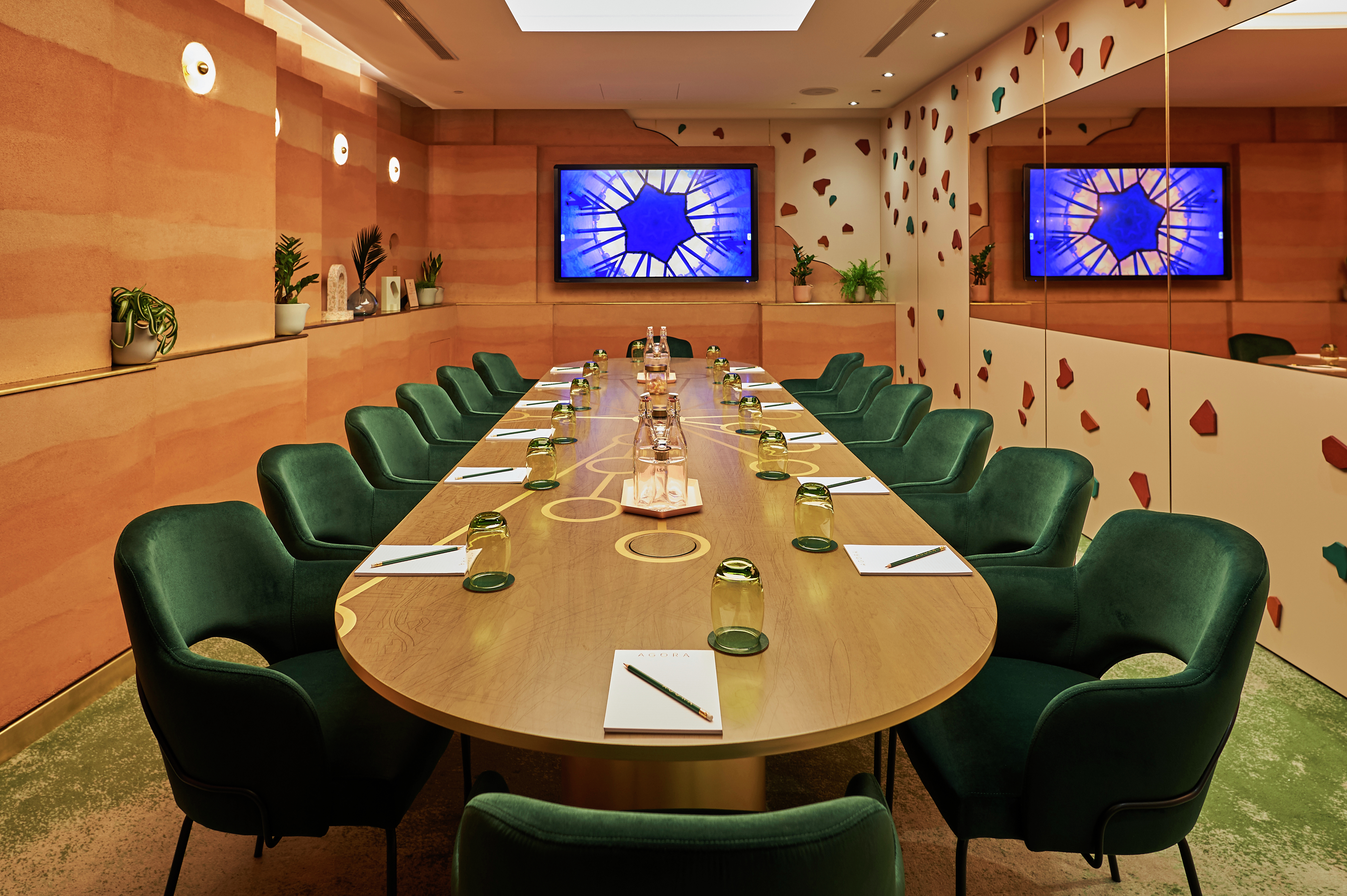 Agora meeting room with large table and 14 green chairs, distinct blue star wall art