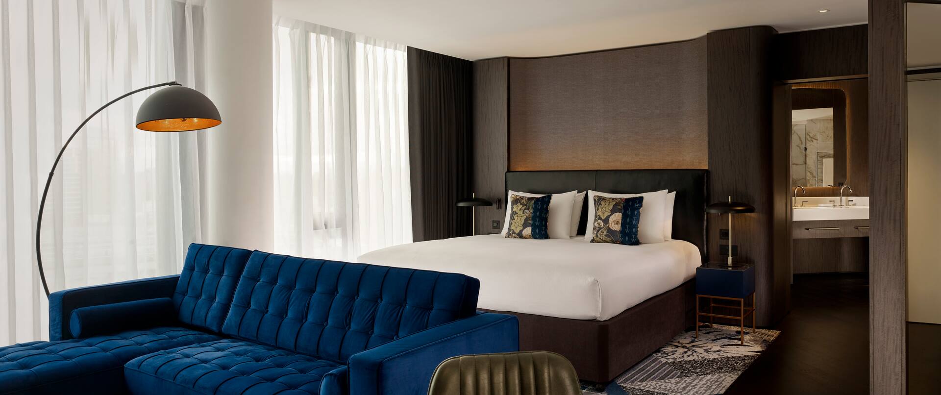 Master Suite mit Kingsize-Bett, Blick aufs Bett und das blaue Sofa