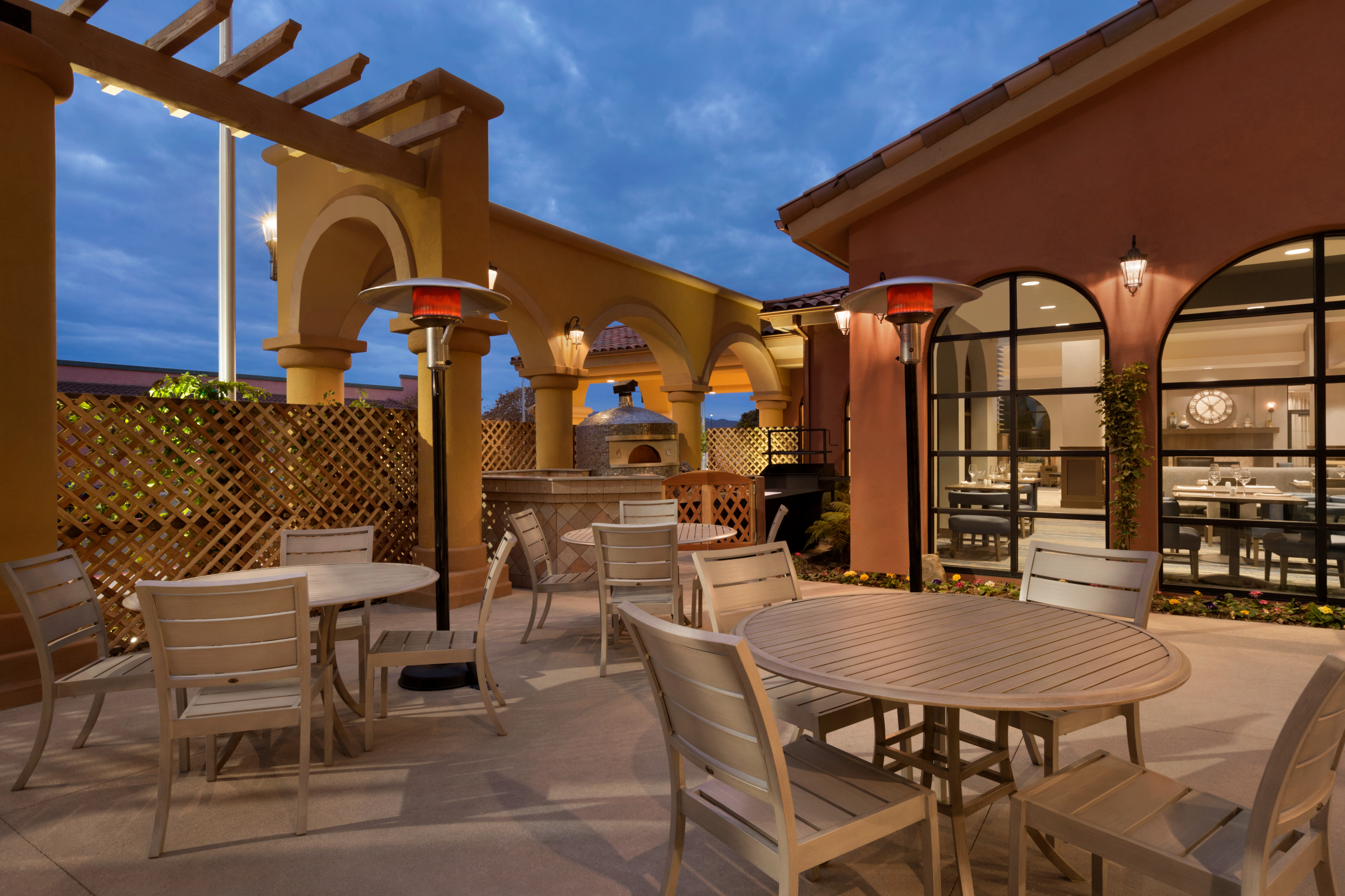 Outdoor Patio Seating Area with Chairs and Tables at Night