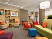 Colorful and Comfortable Seating in Lobby by TV and View of Snack Shop in the Background