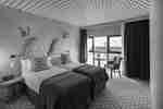 Double Guest Bedroom With Lounge Chair Near Large Window with City View