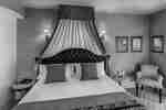 King Guestroom With Unique Headboard and Lounge Chair