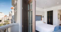 View Through Open Terrace Door of King Bed, and Bed Bench in Superior Guest Room