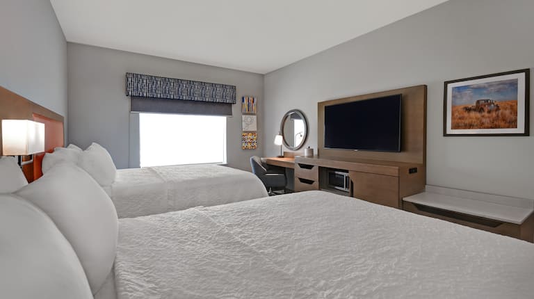 guest room with two beds window and television