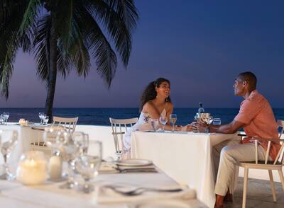 Couple enjoying water-front romantic dinner at an all-inclusive resort in Jamaica