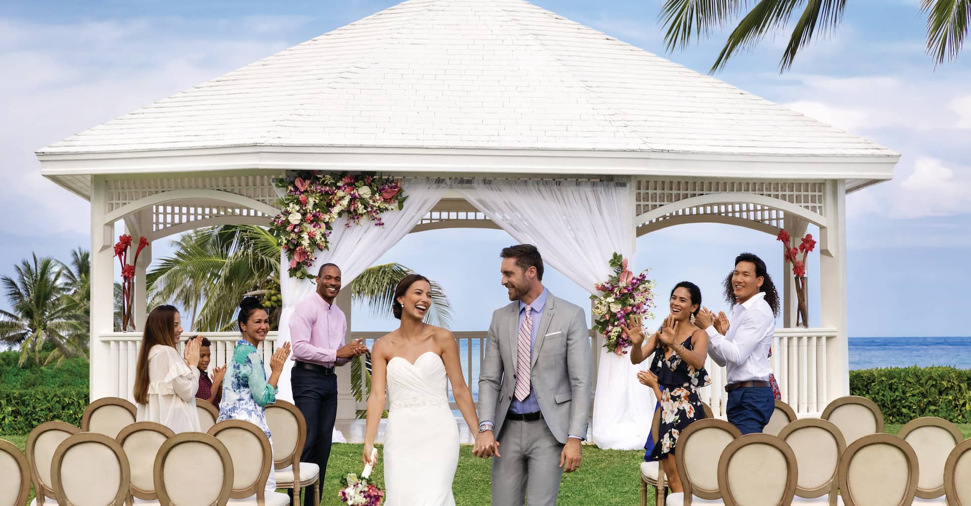 All-inclusive resort in Jamaica Happy just-married couple exiting ceremony at Hilton Rose Hall Resort & Spa