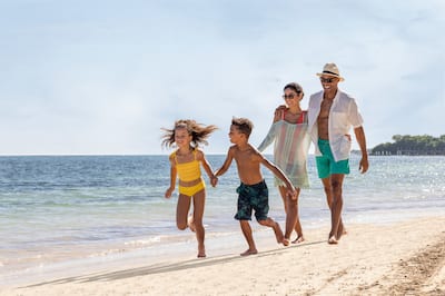African American family enjoying a walk on the beach at Hilton Rose Hall Resort & Spa, an all-inclusive resort.