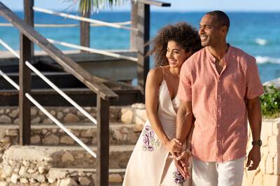 African American couple holding hands as they look out at the sea at Hilton Rose Hall Resort & Spa, an all-inclusive resort.