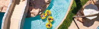 A family of four tubing around a lazy river at Hilton Rose Hall Resort & Spa, an all-inclusive resort.