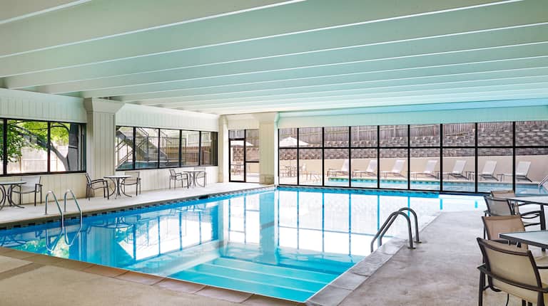 Indoor Pool with Sitting Area and View of Outdoor Pool