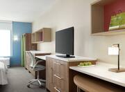 Bright studio suite with work desk, TV, and two comfortable queen beds.