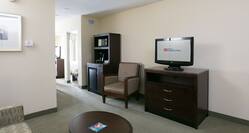Guest Lounge Area with HDTV, Armchair, Sofa and Coffee Table