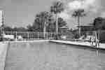 Outdoor pool with chairs around it during the day