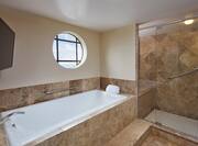 Presidential Suite Bathroom with Tub, Shower and Wall Mounted Television