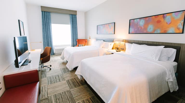 Guest Room with Two Queen sized Beds Desk and HDTV