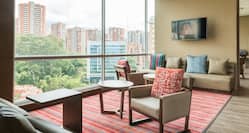 Tables, Soft Seating, and Large Windows With City View in Executive Lounge