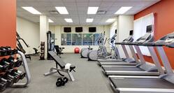 Fitness Center With TVs, Red Stability Ball, Cardio Equipment, Bench, Free Weights, Weight Machine, and Weight Balls