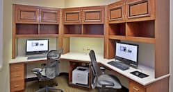 Business Center With Two Computer Workstations, Ergonomic Chairs, and Printer on Large Wooden Desk