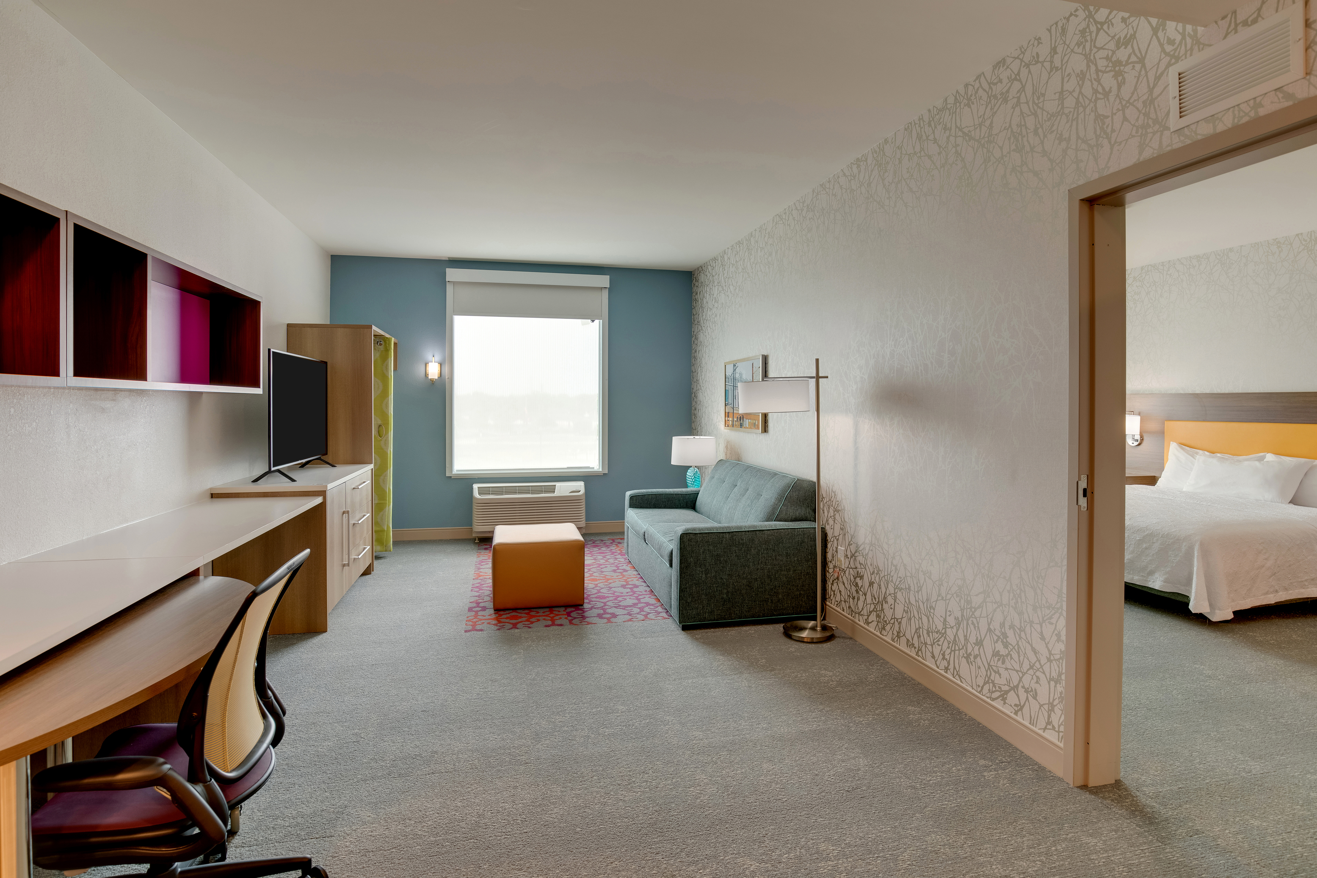 guest suite lounge area, work desk, tv, sofa, bedroom view