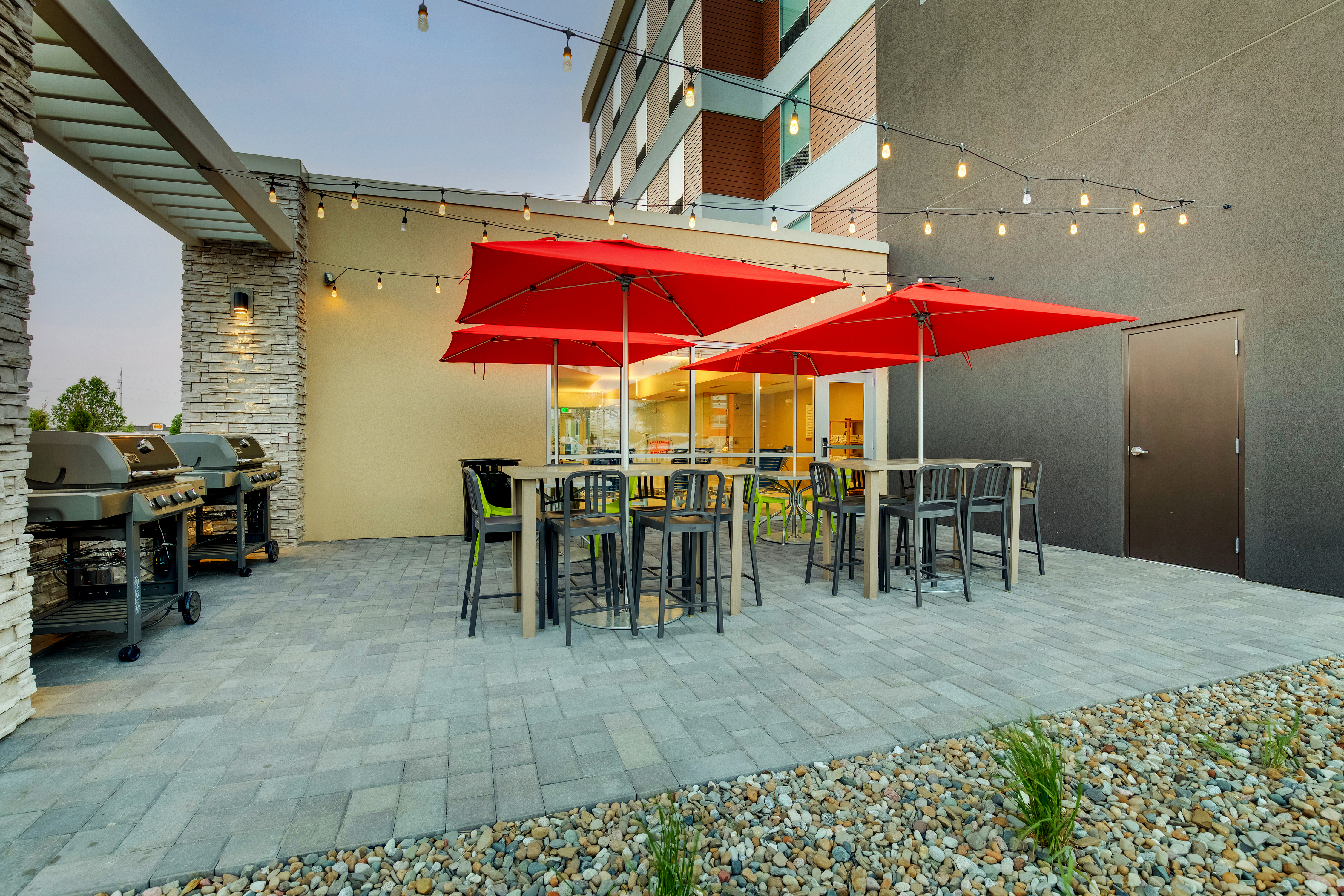 outdoor patio, bbq grills, tables, chairs, red umbrellas