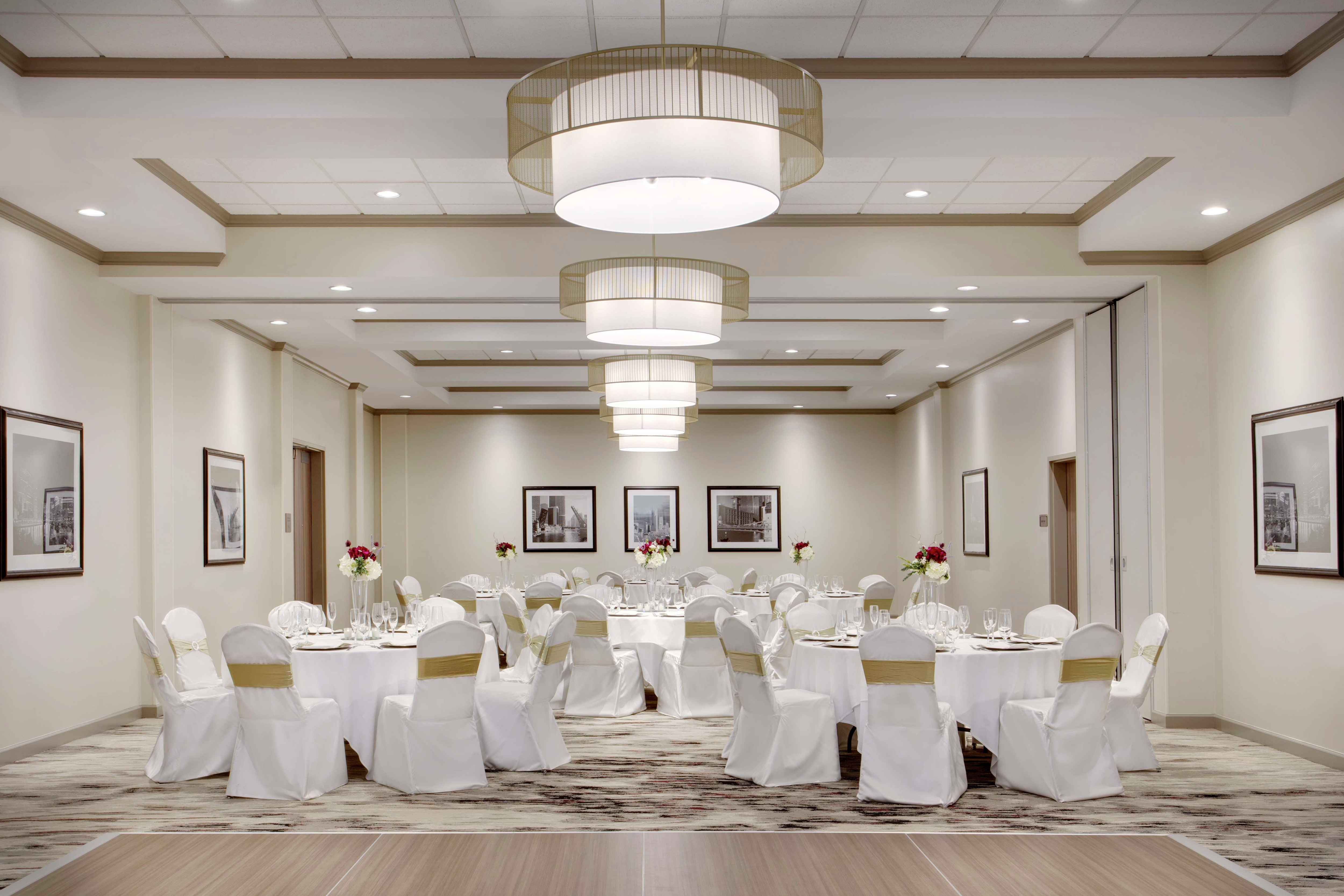 white covered chairs and round banquet tables in a meeting room