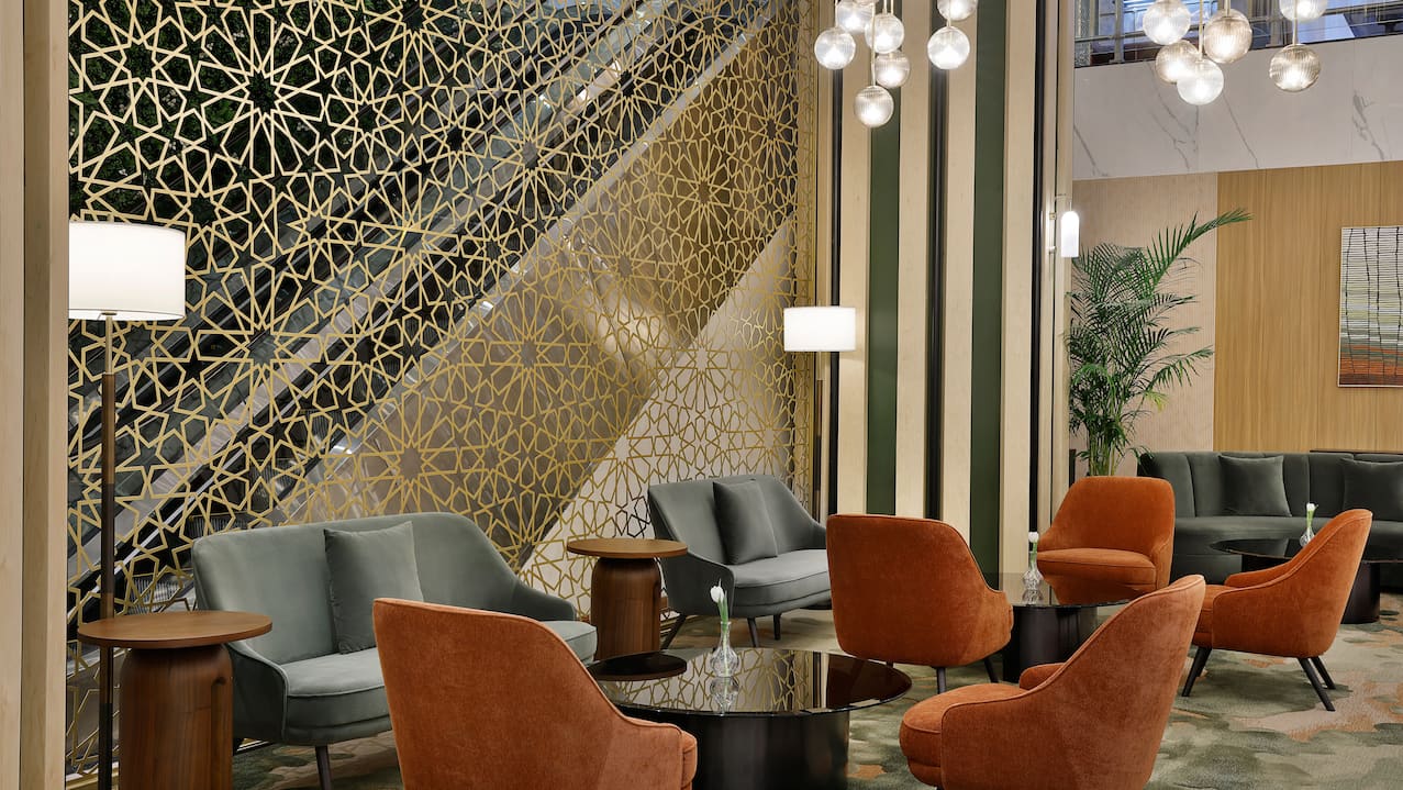 Lobby with seating area, chandeliers and staircase