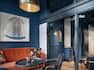 Shot of Bishop Restaurant with dark panelled walls and orange and blue seating areas.