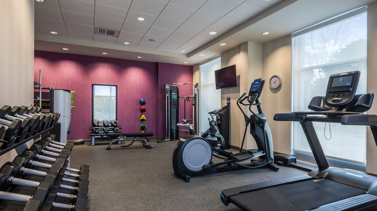 Fitness Center with HDTVs Treadmills Elliptical Machine and Weights