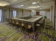 Meeting Room With U-Shaped Table, Chairs, and Windows With Long Drapes