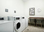 Laundry Room with Washing Machines, Table, and Chairs