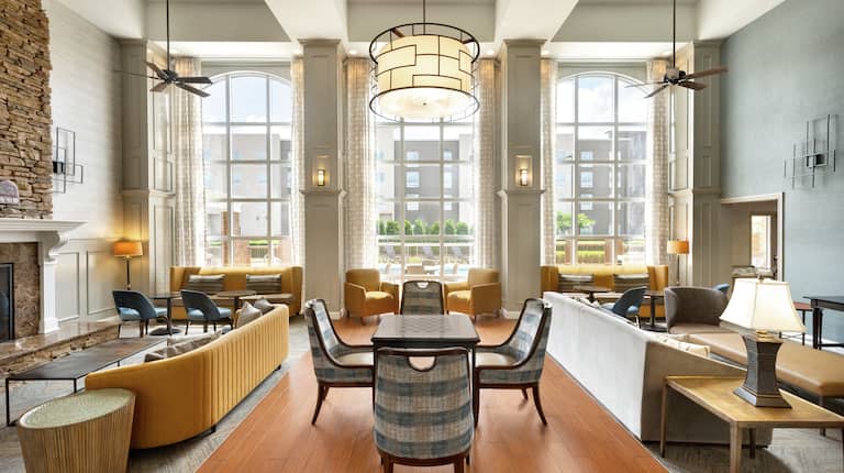 Spacious lobby featuring ample comfortable seating, floor to ceiling windows, and stone fireplace.