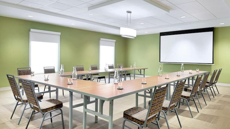 U-Shaped Table Setup in Meeting Room with Projector Screen
