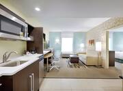 One Bedroom Suite Kitchen and Living Area with Doorway Open to Bedroom
