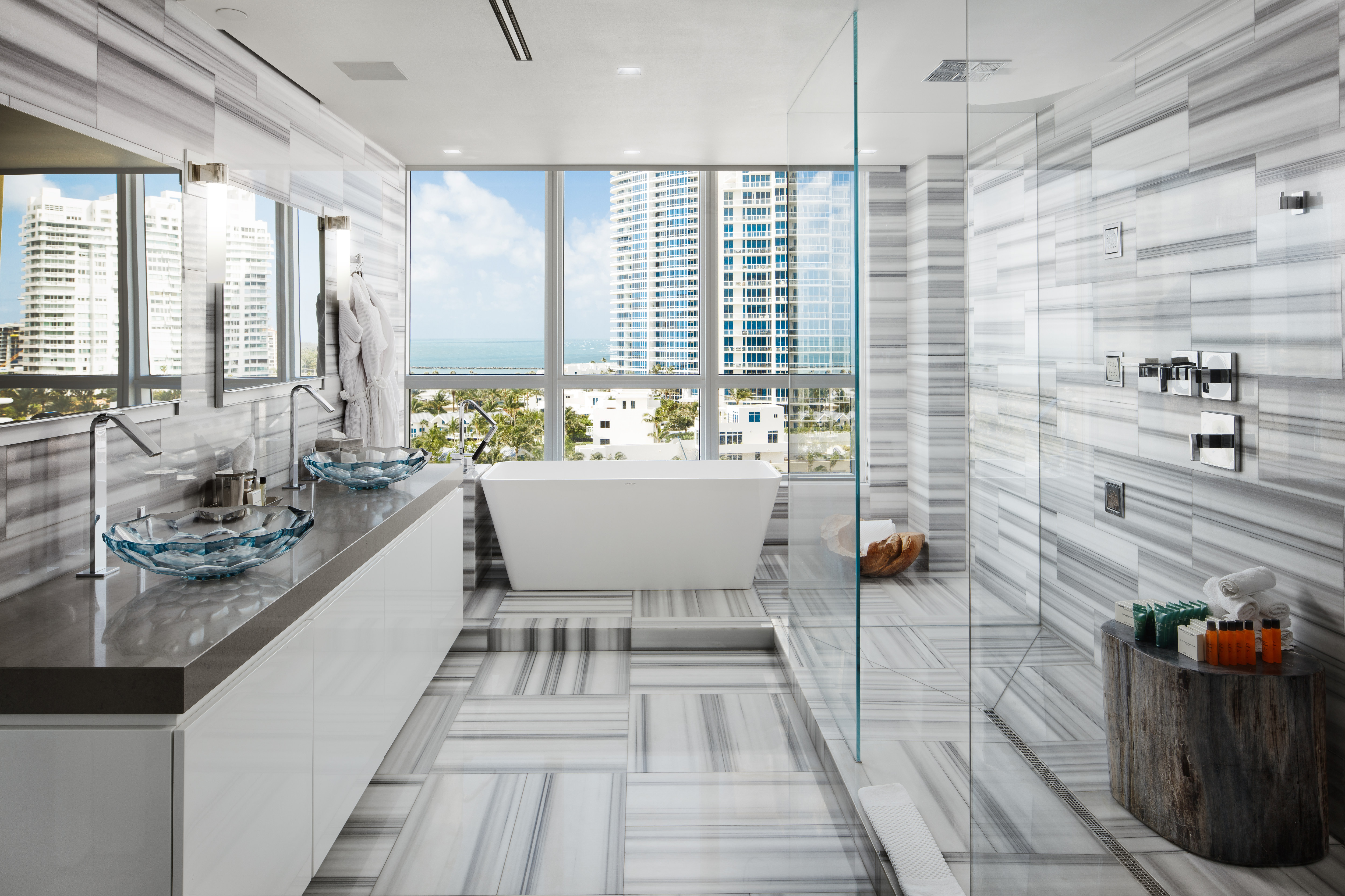 Penthouse bathroom with dual vanity area bathtub and large windows with city view
