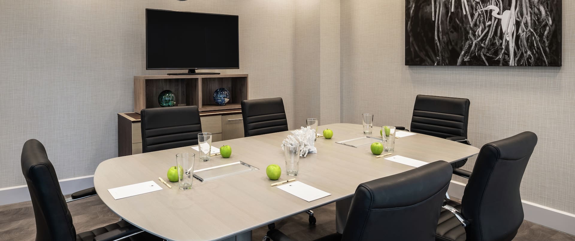 a meeting table with six leather chairs in a meeting room