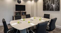 a meeting table with six leather chairs in a meeting room