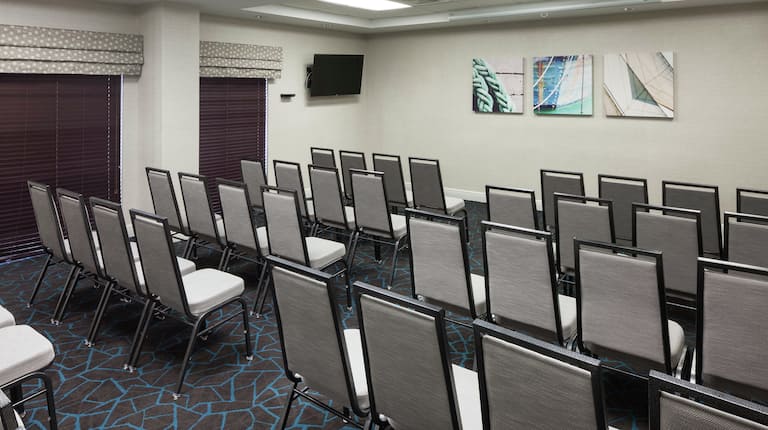 Sala de reuniones con mesas, sillas y tecnología