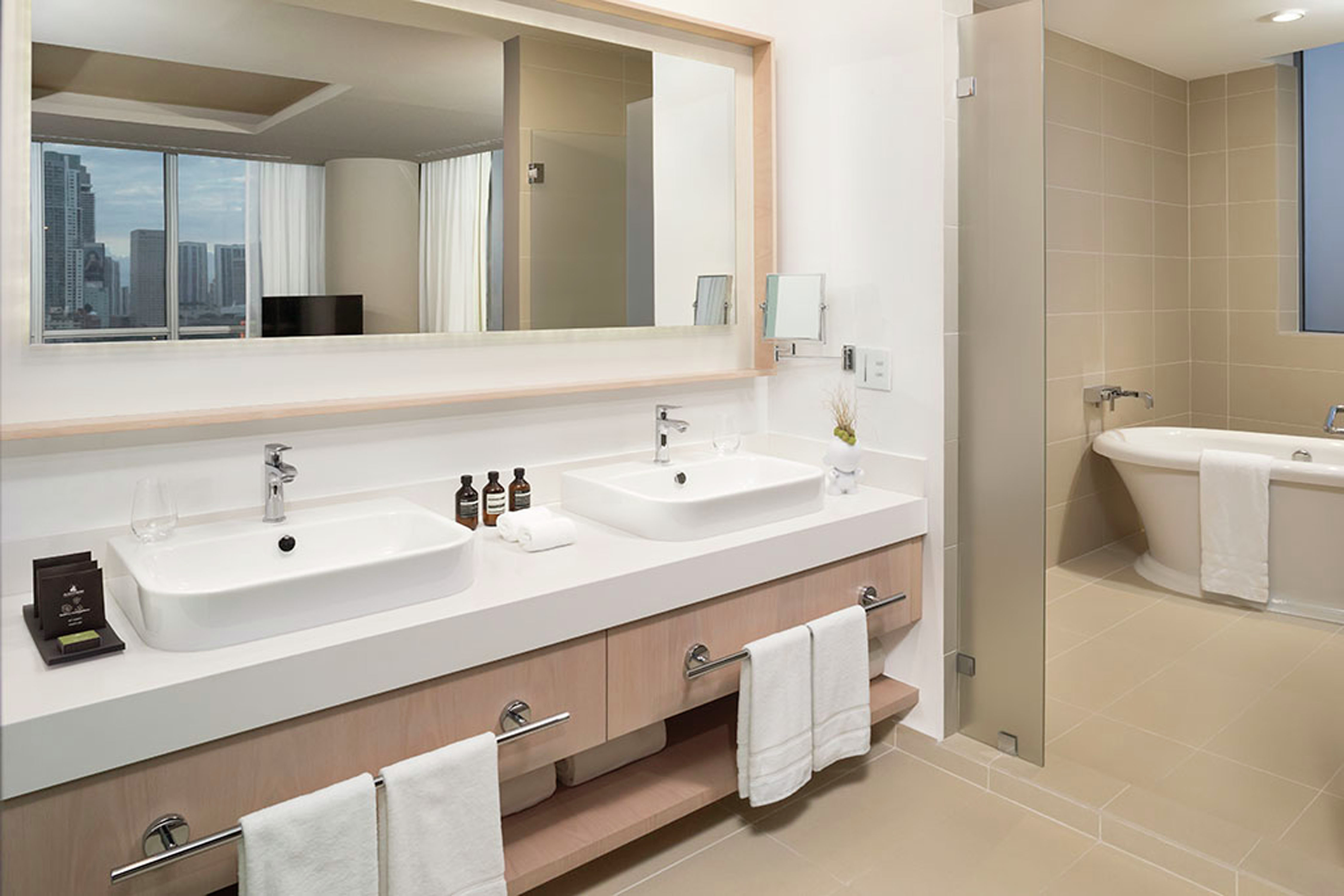 Suite Bathroom with Mirror, Dual Vanity, and Bathtub