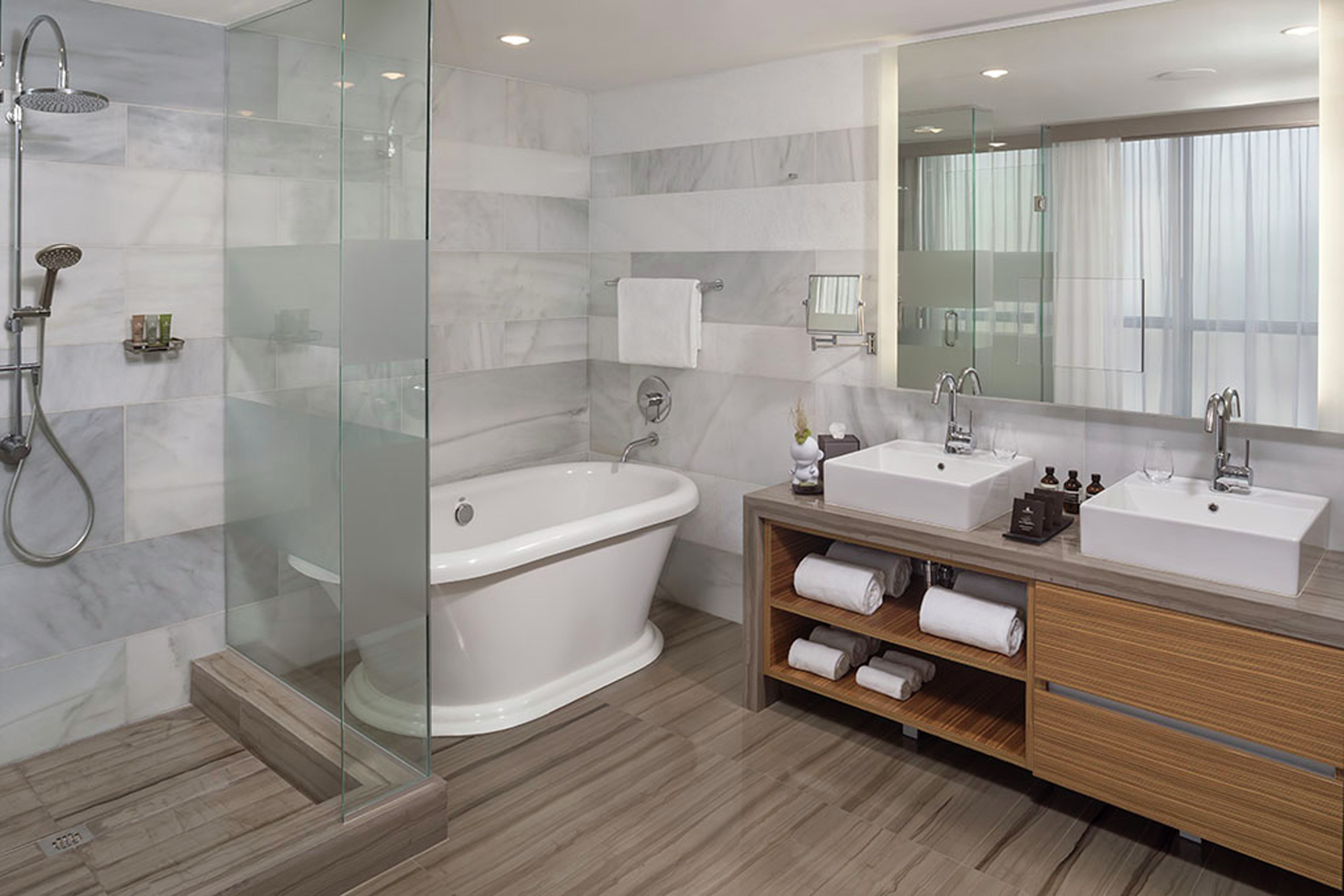 Suite Guestroom with Mirror, Dual Vanity, Walk-In Shower, and Bathtub