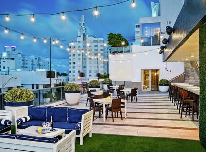 Rooftop Lounge and Seating Area with Hanging Lights at Dusk