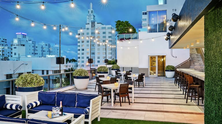 Rooftop Lounge and Seating Area with Hanging Lights at Dusk