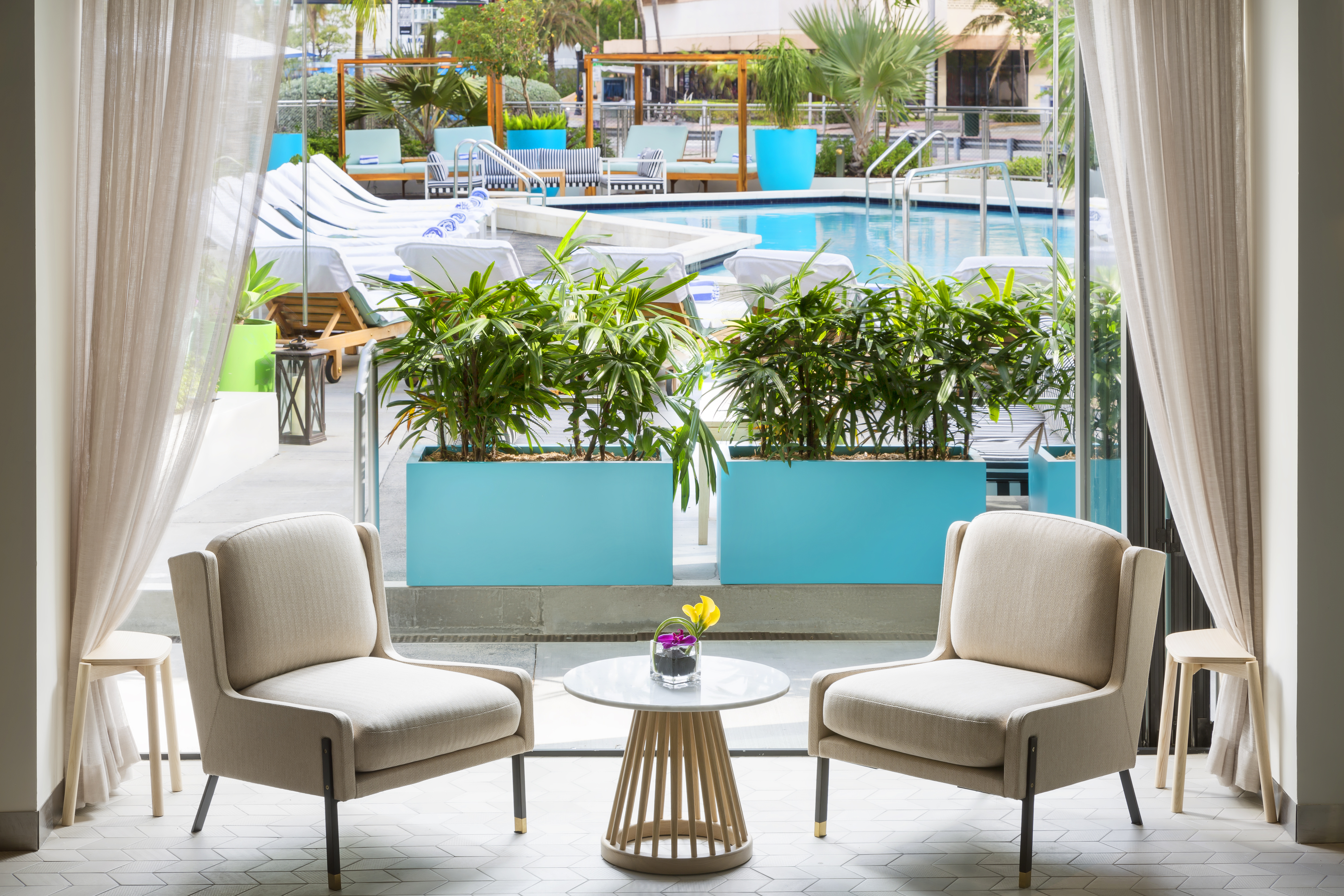 Lobby Seating Area with Two Soft Chairs, Small Table and Outdoor Pool