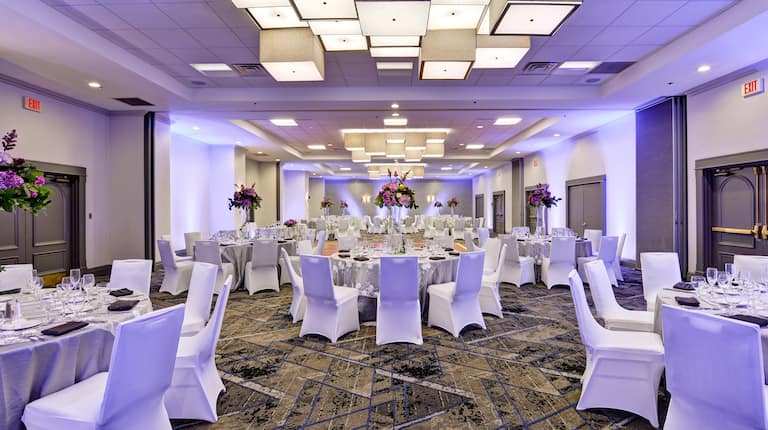 Salón de fiestas con montaje para recepción de bodas, mesas redondas y sillas