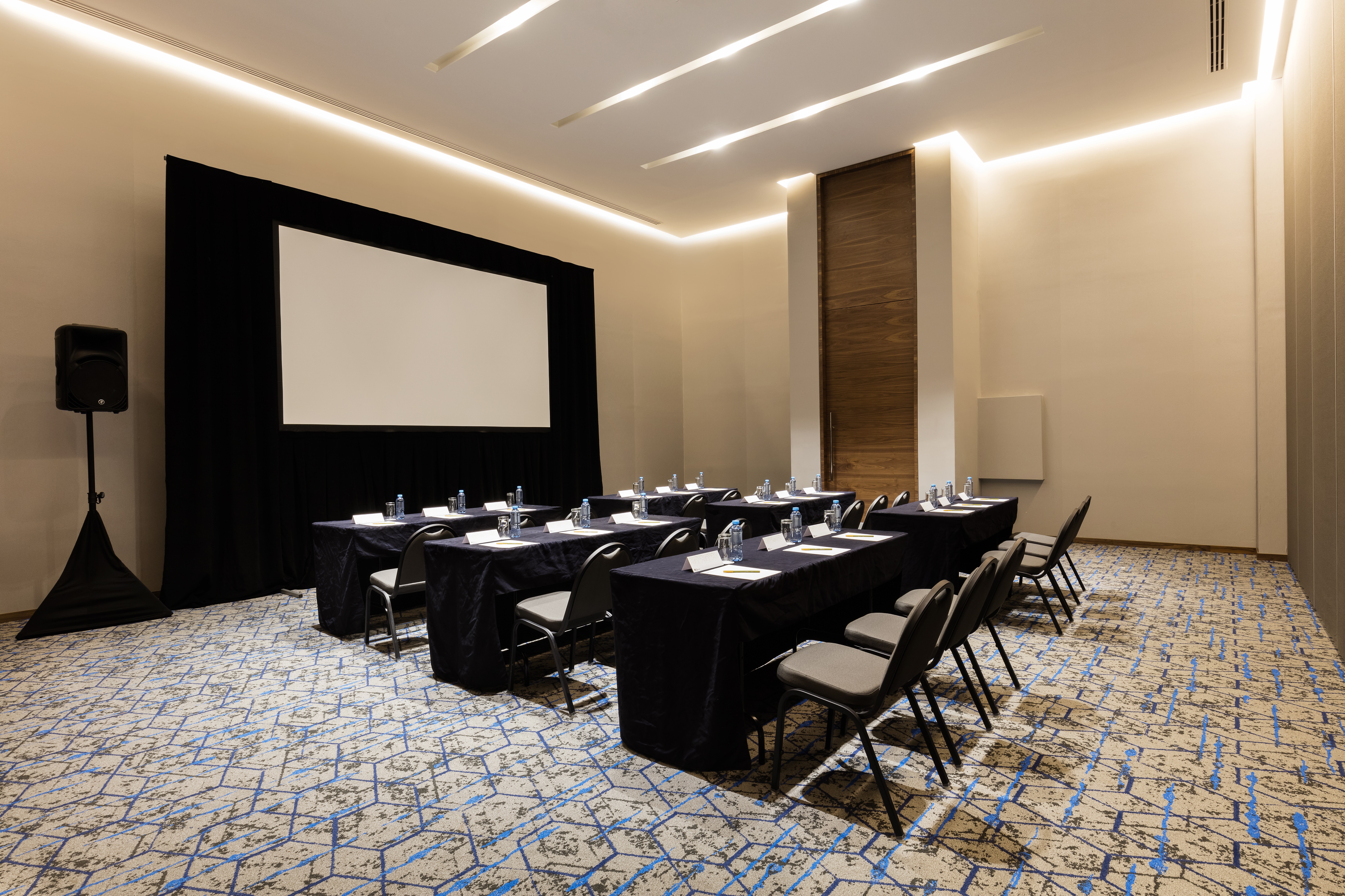 Classroom-Style Tables and Chairs in Yucatan Ballroom Facing Presentation Screen with Side Speakers