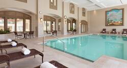 Beautiful indoor pool featuring ample seating, fresh rolled towers, and high coffered ceilings. 