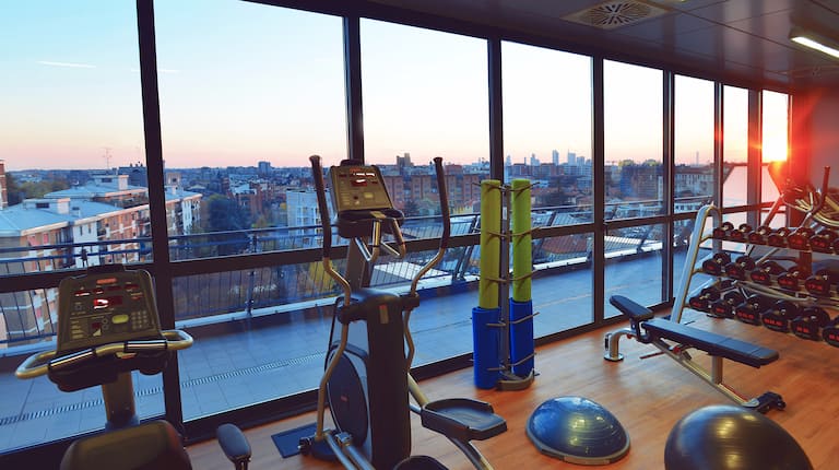 Sala fitness con letto king size e vista panoramica sulla città